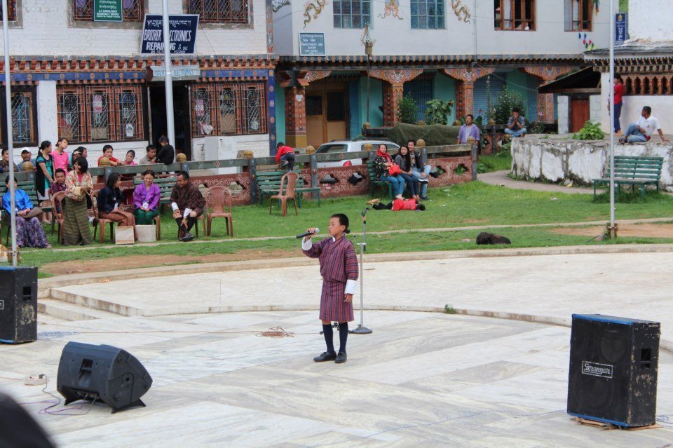 The gho is the traditional dress of Bhutan, worn here by a young star at a community charity concert.